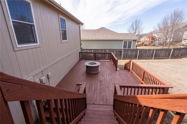 wooden deck featuring a fenced backyard and an outdoor fire pit