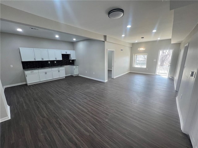 kitchen with visible vents, backsplash, dark wood-style floors, open floor plan, and white cabinets