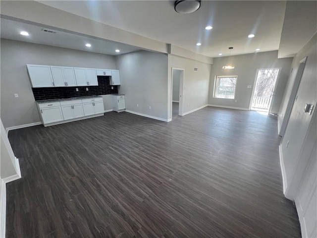 unfurnished living room with recessed lighting, baseboards, and dark wood-style flooring