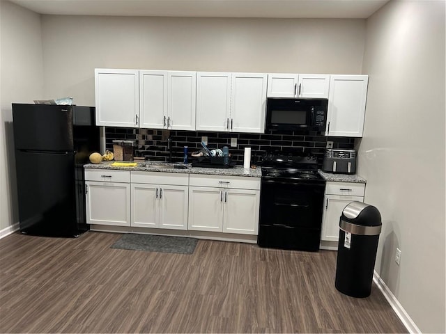 kitchen with backsplash, black appliances, light stone counters, dark wood-style floors, and white cabinetry