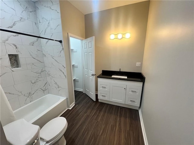 bathroom featuring baseboards, toilet, shower / bathing tub combination, wood finished floors, and vanity