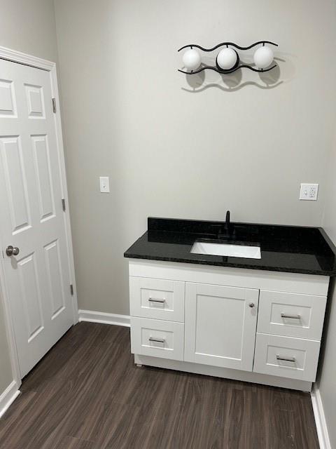 bathroom with baseboards, wood finished floors, and vanity