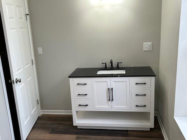 bathroom featuring vanity, wood finished floors, and baseboards