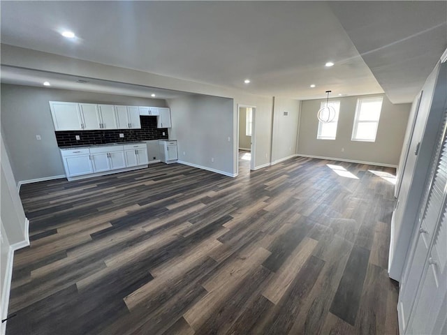 unfurnished living room featuring dark wood finished floors, recessed lighting, and baseboards