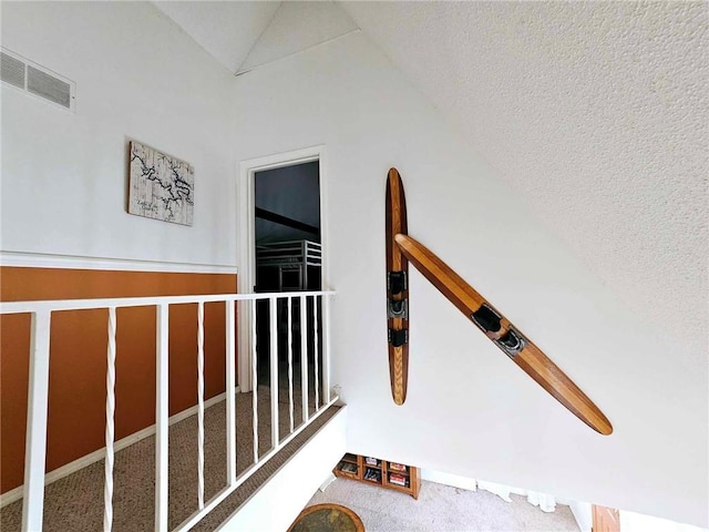 interior space featuring visible vents, lofted ceiling, and carpet floors