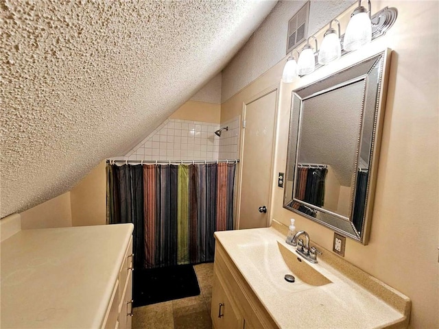 bathroom featuring visible vents, a textured ceiling, walk in shower, vanity, and vaulted ceiling