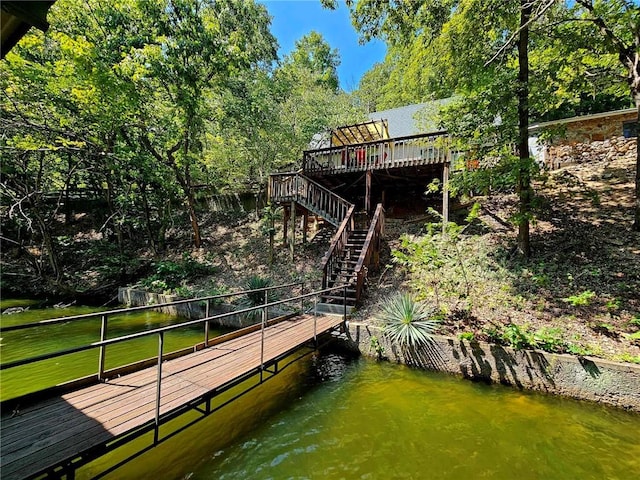 dock area with stairs and a deck with water view