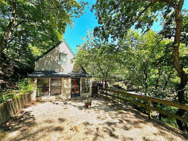 rear view of property featuring fence