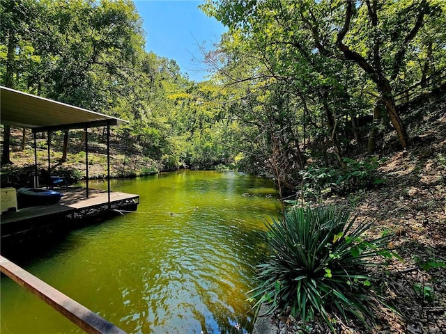 dock area featuring a forest view and a water view