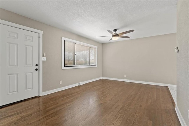 foyer entrance featuring baseboards, a textured ceiling, wood finished floors, and a ceiling fan