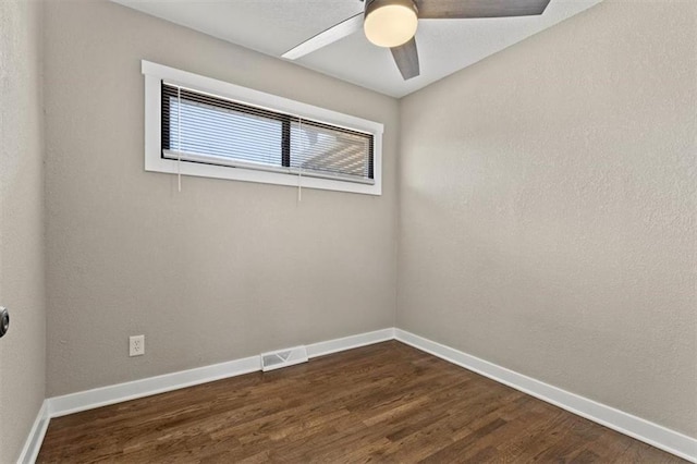 spare room with visible vents, baseboards, ceiling fan, and dark wood-style flooring