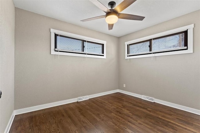 empty room featuring visible vents, wood finished floors, baseboards, and ceiling fan