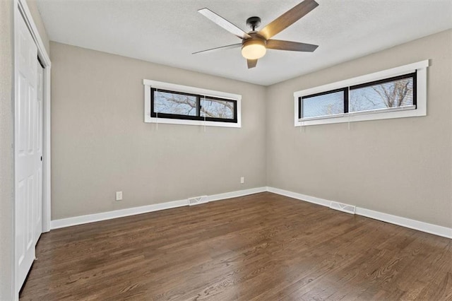 unfurnished bedroom with visible vents, a ceiling fan, wood finished floors, a closet, and baseboards