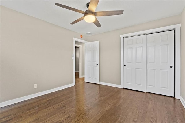 unfurnished bedroom with a ceiling fan, wood finished floors, baseboards, and a closet