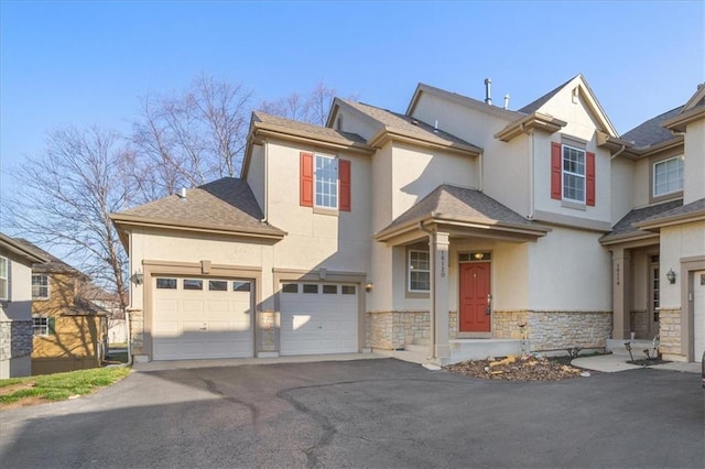 view of front of property featuring aphalt driveway, stone siding, and stucco siding