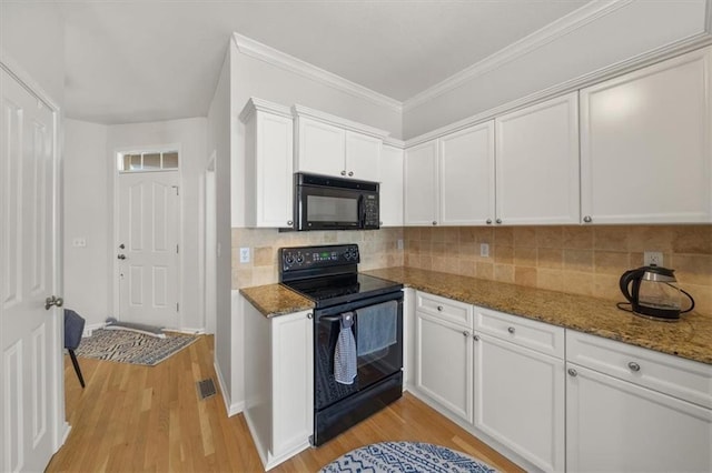 kitchen featuring decorative backsplash, dark stone countertops, black appliances, and light wood-type flooring