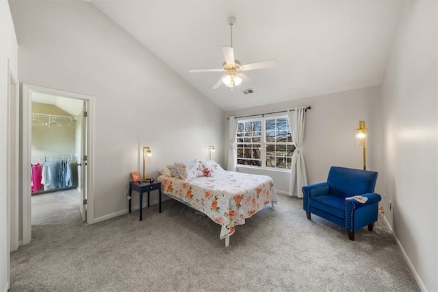 carpeted bedroom with visible vents, a walk in closet, baseboards, high vaulted ceiling, and a ceiling fan