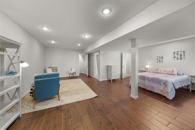 bedroom with recessed lighting, a textured ceiling, baseboards, and wood finished floors