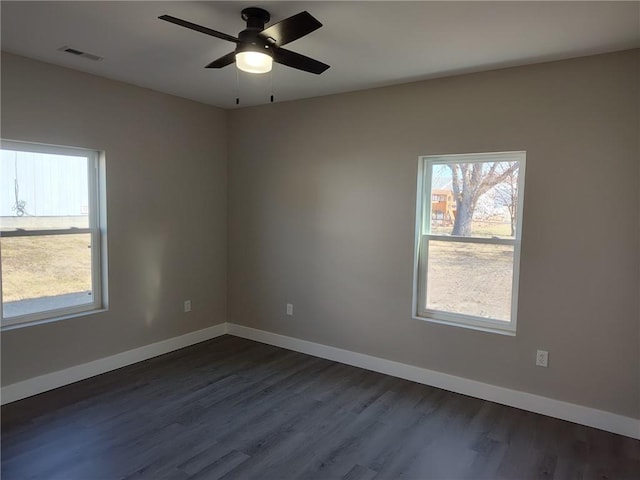 unfurnished room with visible vents, baseboards, ceiling fan, and dark wood-style flooring