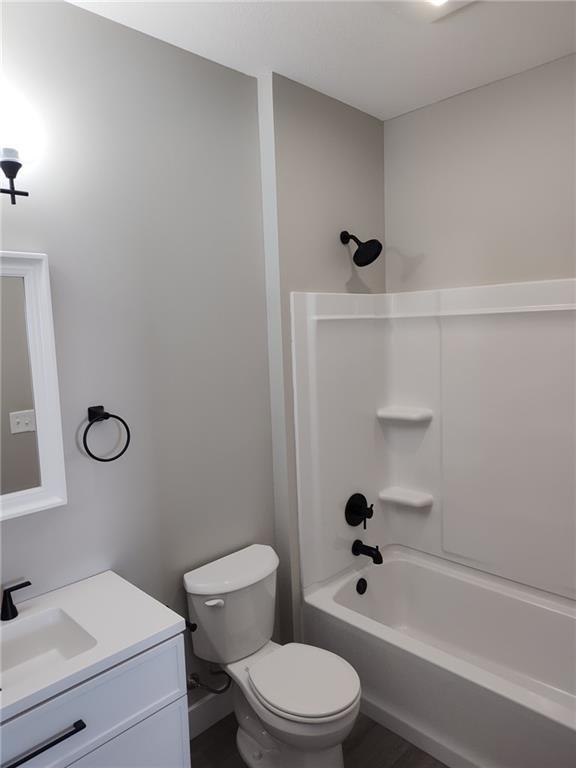 full bath with shower / tub combination, toilet, and vanity