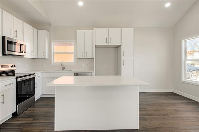 kitchen with a sink, decorative backsplash, lofted ceiling, and appliances with stainless steel finishes