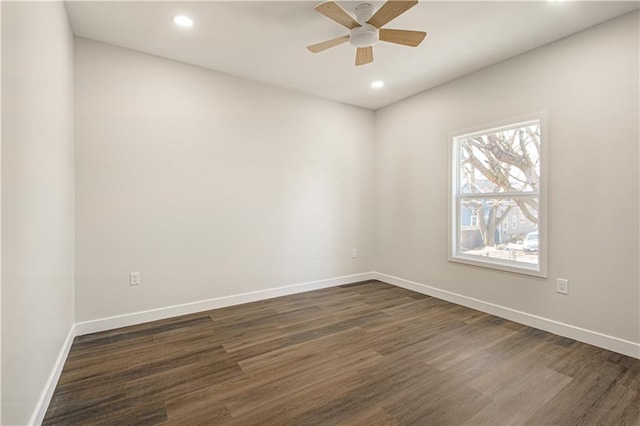 unfurnished room featuring a ceiling fan, dark wood-style floors, and baseboards