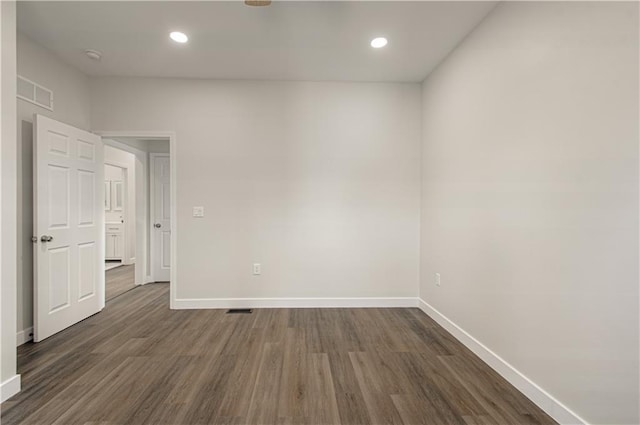 unfurnished room with recessed lighting, dark wood-style floors, and baseboards