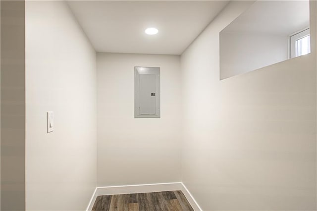 interior space featuring electric panel, dark wood-style floors, and baseboards