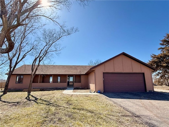 view of front of property featuring a front lawn, an attached garage, and driveway