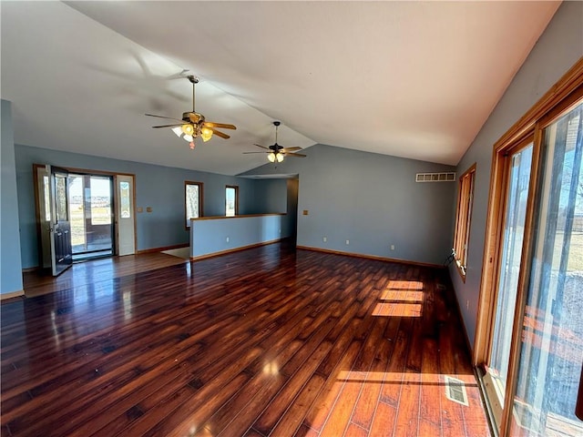 spare room featuring visible vents, lofted ceiling, baseboards, and hardwood / wood-style floors