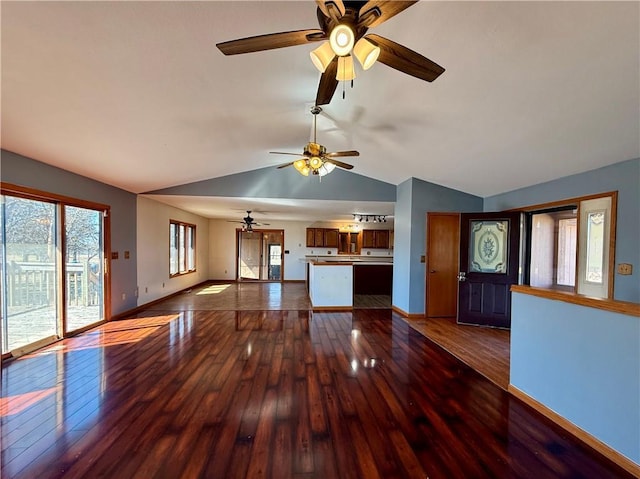 unfurnished living room with hardwood / wood-style floors, lofted ceiling, and baseboards