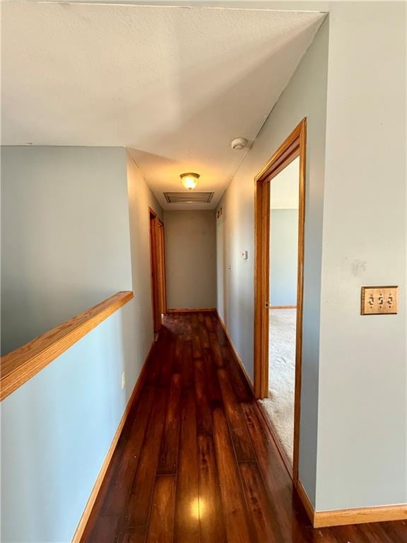 hallway featuring visible vents, baseboards, and wood-type flooring