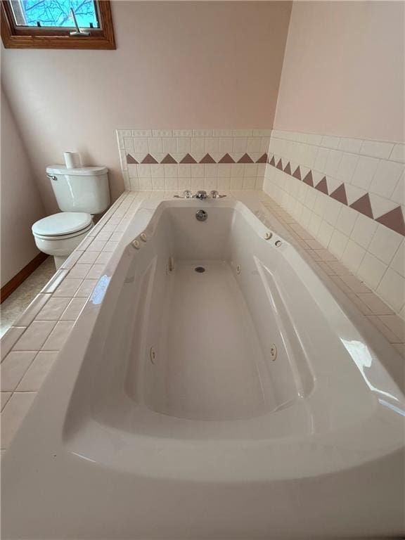 room details featuring toilet and a whirlpool tub