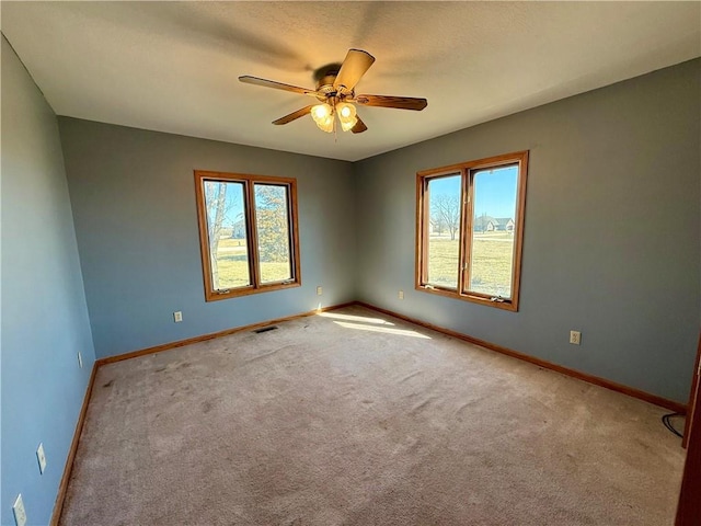 spare room with visible vents, ceiling fan, carpet, baseboards, and a textured ceiling