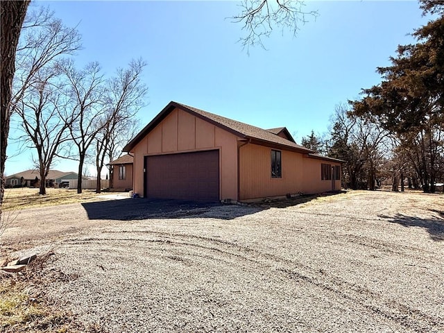 view of home's exterior featuring gravel driveway and an attached garage