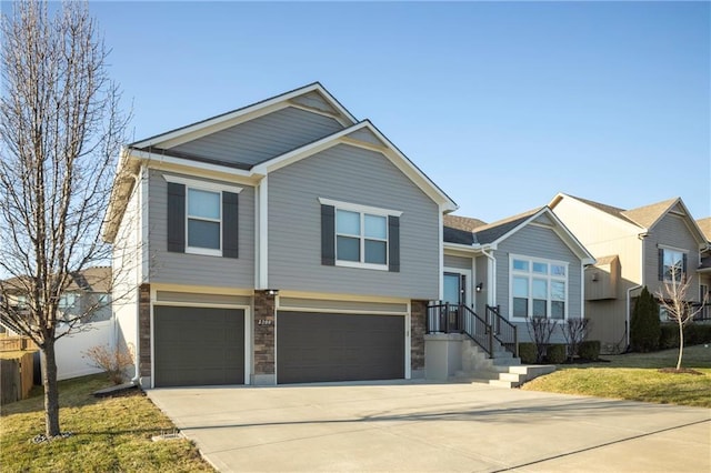 view of front of house featuring stone siding, driveway, and a garage