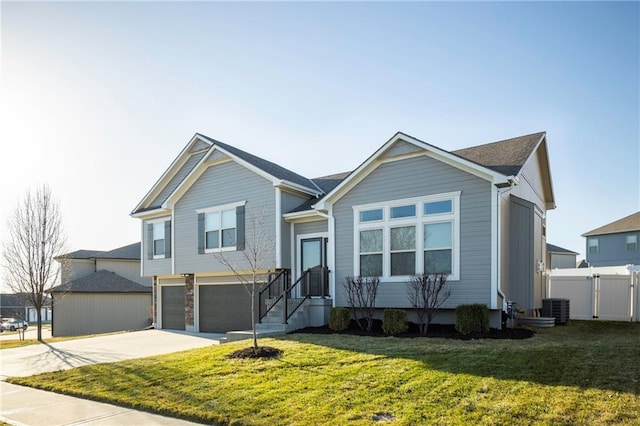 view of front of property featuring driveway, a front lawn, an attached garage, and fence