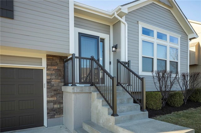 entrance to property with a garage and stone siding