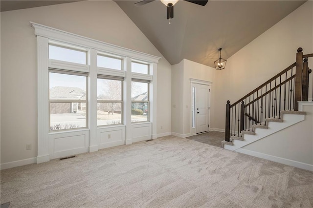 foyer featuring high vaulted ceiling, visible vents, carpet, and stairs