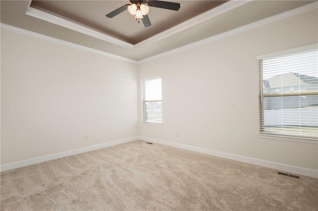 unfurnished room featuring visible vents, a raised ceiling, light colored carpet, and baseboards