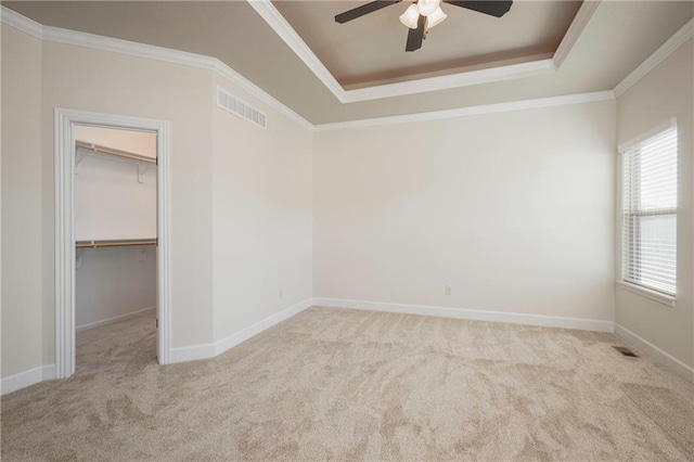 unfurnished room featuring a raised ceiling, carpet, and visible vents