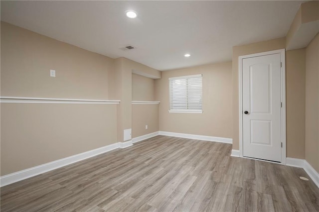 empty room with recessed lighting, visible vents, baseboards, and wood finished floors