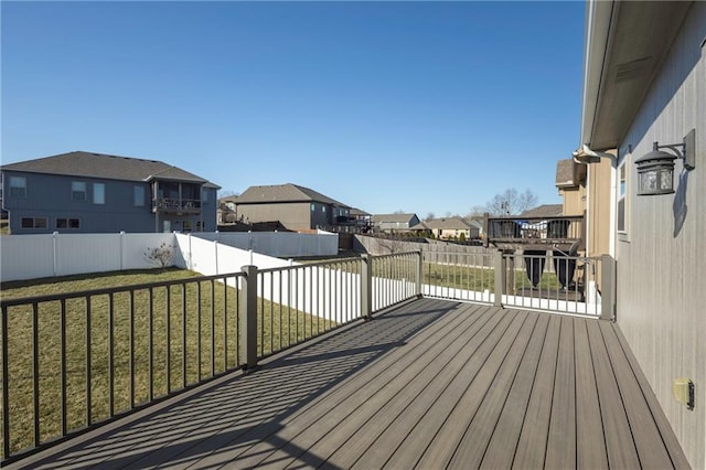 deck featuring a yard, a residential view, and a fenced backyard