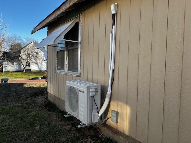 view of side of home featuring ac unit and a lawn