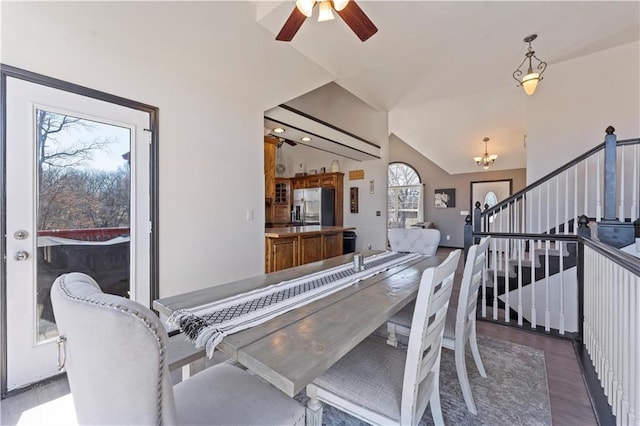 dining area featuring ceiling fan with notable chandelier, stairs, lofted ceiling, and wood finished floors