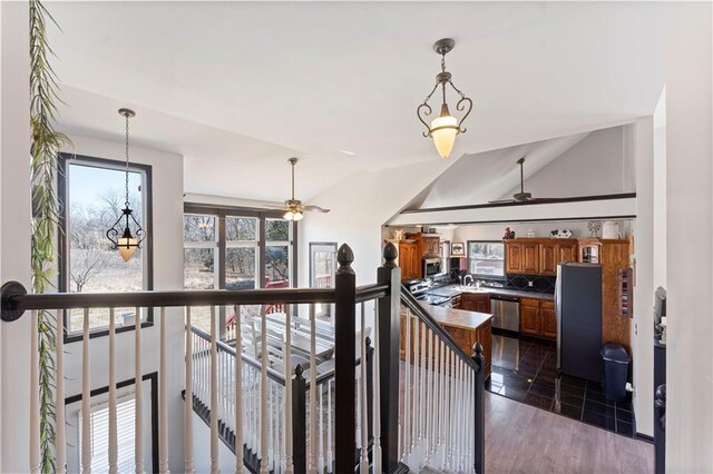 staircase featuring lofted ceiling, wood finished floors, and a ceiling fan