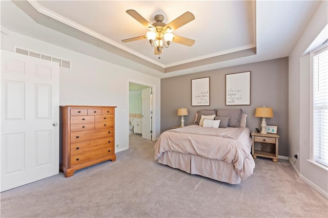 bedroom with a tray ceiling, multiple windows, light carpet, and visible vents