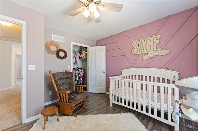 bedroom featuring a ceiling fan, wood finished floors, visible vents, baseboards, and a closet