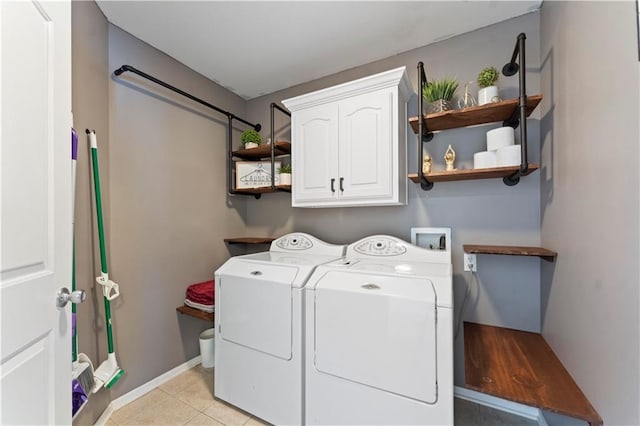 washroom featuring light tile patterned floors, cabinet space, baseboards, and washer and clothes dryer