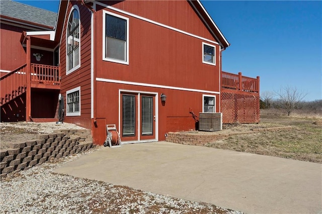 rear view of house with central air condition unit, a deck, and a patio area